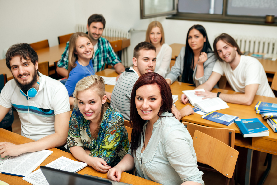 Gruppe fröhlicher junger Menschen im Klassenraum